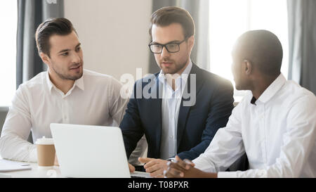 Trois hommes d'affaires travaillent ensemble collaborant sur laptop in office Banque D'Images