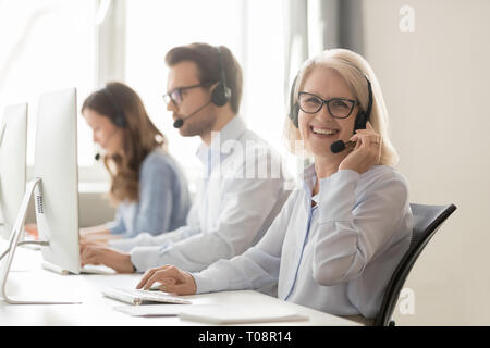 Mature femme agent de centre d'appels à la caméra en souriant Banque D'Images