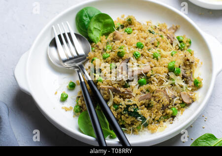 Le quinoa avec les pois verts, les épinards et champignons, repas végétarien sain Banque D'Images