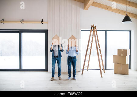 D'hommes occupant des maisons en bois sur la tête lors de l'ameublement d'une maison, d'un concept. Banque D'Images