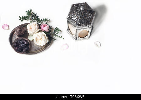 Ramadan Kareem carte de vœux, invitation. Lanterne d'argent, bronze, fruits dates tasse à café, fleurs roses, branches vertes sur l'ancien bac. tableau blanc backg Banque D'Images