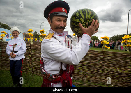 Participant du cinquième festival international 'village cosaque Moscow' dans le parc Kolomenskoye vient avec une pastèque sur la scène du festival Banque D'Images