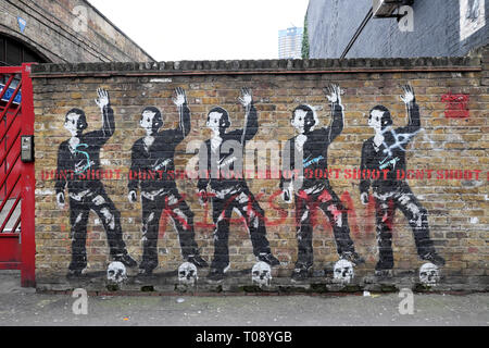 Jeune garçon avec pied debout sur le crane dans Bambi 'Don't Shoot' street art on Rivington Street à Shoreditch East London UK KATHY DEWITT Banque D'Images