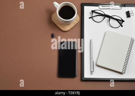 Télévision créative lay, vue de dessus table office 24. Avec l'espace vide du clip, les fournitures de bureau, stylo, bloc-notes, smartphone, verres et tasses à café sur un Banque D'Images