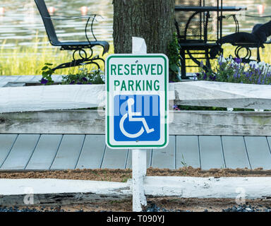 Une place de parking pour handicapés signe est placé près de l'eau pour le bénéfice de la personne à une plage locale avec de l'eau dans l'arrière-plan. Banque D'Images