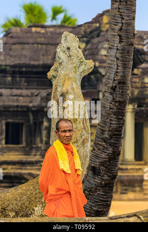 Le moine bouddhiste en robe orange par naga snake statue sur le célèbre Angkor Wat temple bouddhiste ; Angkor, Siem Reap, Cambodge. Banque D'Images