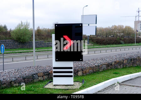 Tableau de bord électronique avec flèche rouge pointeur sur station d'essence. Affichage numérique on city street Banque D'Images