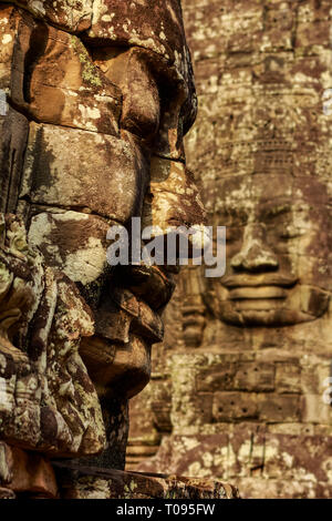 Deux des 216 smiling faces de grès à 12thC Bayon, temple du dernier roi Jayavarman VII à Angkor Thom, Angkor, Siem Reap, Cambodge. Banque D'Images