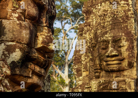 Deux des 216 smiling faces de grès à 12thC Bayon, temple du dernier roi Jayavarman VII à Angkor Thom, Angkor, Siem Reap, Cambodge. Banque D'Images