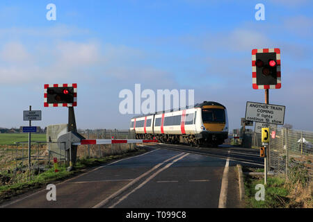 Abellio une plus grande Anglia, Turbostar 170273 le passage d'un passage à niveau sans pilote, la ville de mars, Fenland, Cambridgeshire, Angleterre. Banque D'Images