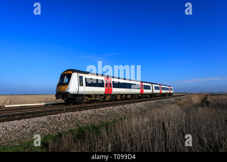 Abellio une plus grande Anglia, Turbostar 170273 le passage d'un passage à niveau sans pilote, la ville de mars, Fenland, Cambridgeshire, Angleterre. Banque D'Images