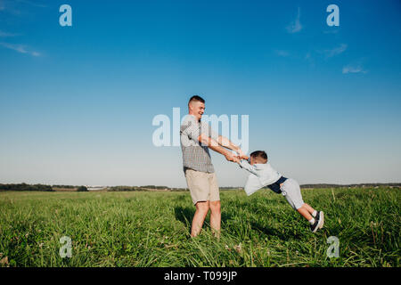 Cheerful papa jouant avec son enfant au niveau du terrain Banque D'Images