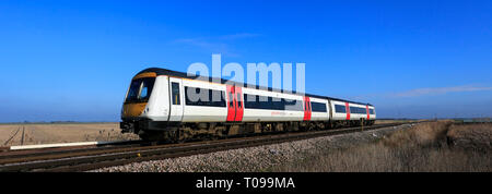 Abellio une plus grande Anglia, Turbostar 170273 le passage d'un passage à niveau sans pilote, la ville de mars, Fenland, Cambridgeshire, Angleterre. Banque D'Images