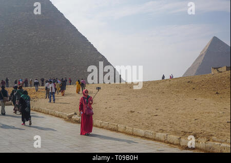 Giza, Egypte : une femme portant un hijab en tenant une pyramide Khufu selfies au complexe. Banque D'Images