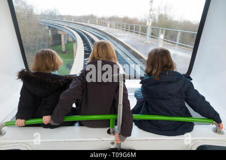 Trois sœurs, filles, enfants, enfants, montent le service de navette inter-terminal, le train shuffle de Gatwick entre le terminal nord et les terminaux sud de l'aéroport de Gatwick, Londres, Royaume-Uni. (104) Banque D'Images