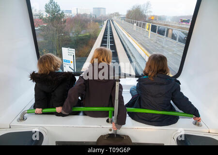 Trois sœurs, filles, enfants, enfants, montent le service de navette inter-terminal, le train shuffle de Gatwick entre le terminal nord et les terminaux sud de l'aéroport de Gatwick, Londres, Royaume-Uni. (104) Banque D'Images