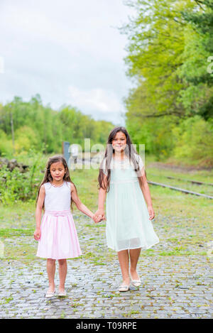 Deux petites soeurs marche main dans la main à côté d'un rail de train Banque D'Images