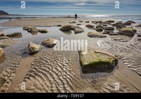 Une plage à marée basse, avec du sable mouillé et de réflexions ; à Charmouth, dans le site du patrimoine mondial de la Côte Jurassique, Dorset, Grande Bretagne. Banque D'Images