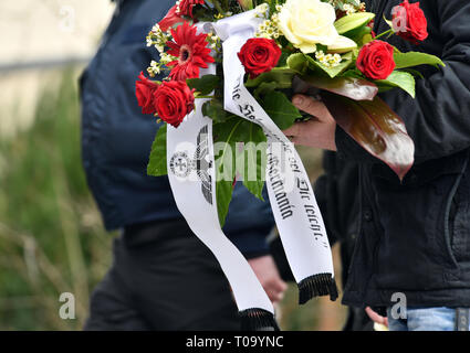 Chemnitz, Allemagne. 18 Mar, 2019. Les participants d'une procession funéraire transporter un arrangement de fleurs au cimetière pour assister à l'enterrement de Thomas Haller, une personne décédée fan de Chemnitzer FC, une équipe de la ligue régionale de soccer. De nombreuses personnes de la scène de droite sont attendus pour assister aux funérailles de l'hooligan et connus à l'extrémiste de droite. L'homme de Chemnitz a été le premier chef de l'ancienne association 'HooNaRa Hooligans-Nazis' (les racistes). Credit : Zentralbild Zentralbild-/dpa/dpa/Alamy Live News Banque D'Images