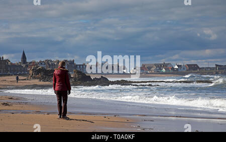 North Berwick, East Lothian, Écosse, 18 mars 2019. Royaume-uni le soleil brillait sur North Berwick, avec du ciel bleu et des nuages, cette dame regarde vers la ville. Banque D'Images