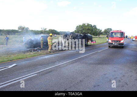 Windhoek, Namibie. Mar 17, 2019. Les pompiers travaillent à proximité les épaves de deux véhicules impliqués dans une collision près de Otavi, le nord de la Namibie, le 17 mars 2019. Le président namibien Hage Geingob le lundi a étendu ses condoléances après 13 passagers ont été brûlés à mort lors d'une collision entre deux mini-bus le long de la route B1 du pays. Selon une déclaration publiée par la Namibie de Police (NAMPOL) Lundi, l'accident est survenu le 17 mars à environ 3 km d'Otavi à Tsumeb sur la route B1. Credit : NAMPA/Xinhua/Alamy Live News Banque D'Images