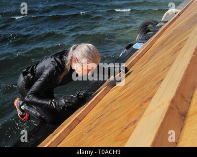 Les personnes actives au cours de l'extrême course à obstacles dans boot camp. Banque D'Images