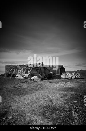 Hareng tournée vers les bateaux utilisés comme hangars de stockage sur l'île de Lindisfarne (Île Sainte) sur la côte du nord de l'Angleterre Northumbrian, UK, FR. Banque D'Images