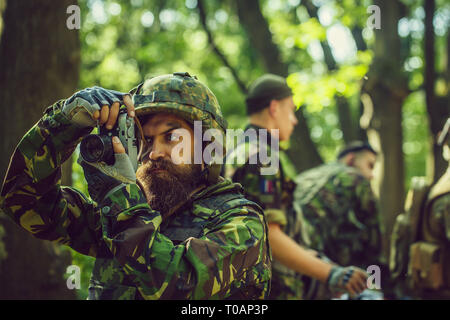 Soldat avec l'appareil photo en forêt Banque D'Images