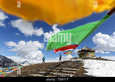 La mère et le fils sur les 4,298m Col Zheduo Shan, à drapeaux de prières avec belle vue sur les montagnes enneigées, Kangding, Shanghai, Chine Banque D'Images