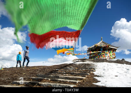 La mère et le fils debout sur le dessus de la 4,298m Col Zheduo Shan, à drapeaux de prières avec belle vue sur les montagnes enneigées, Kangding, Shanghai, Chine Banque D'Images