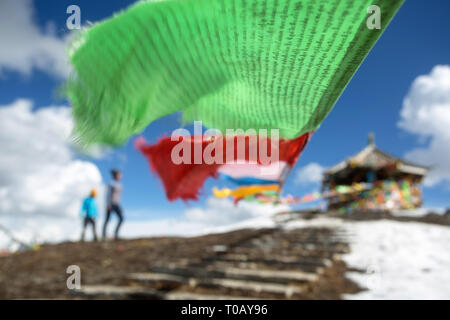 La mère et le fils debout sur le dessus de la 4,298m Col Zheduo Shan, à drapeaux de prières avec belle vue sur les montagnes enneigées, Kangding, Shanghai, Chine Banque D'Images