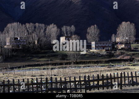 Maison de village sur une colline, l'ombre des montagnes en arrière-plan, Sichuan, Chine Banque D'Images