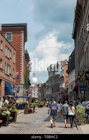 Montréal, Québec, Canada. À l'est vers le bas à l'Est de la rue Saint Paul Rue Saint Gabriel à des personnes et des bâtiments avec des drapeaux dans le Vieux Montréal. Banque D'Images