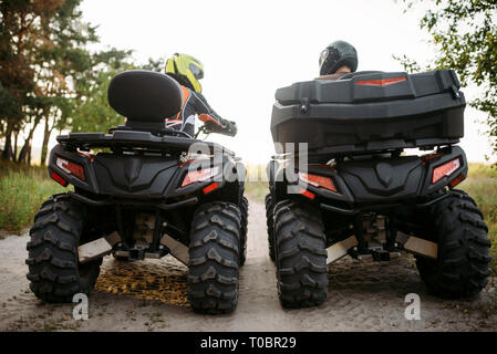 Deux vtt dans casques, vue arrière. Freeride sur quad, sport extrême et de voyage, aventure estivale quadbike Banque D'Images