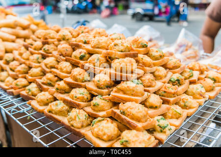 Une nourriture de rue appelé 'pain frit avec porc haché propagation' pour la vente au marché local à Bangkok, Thaïlande. Banque D'Images