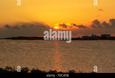 Le soleil se couche sur la baie de Chetumal sur Ambergris Caye, Belize casting teintes brillantes dans le ciel et se reflétant dans les eaux a ondulé par une brise chaude. Banque D'Images