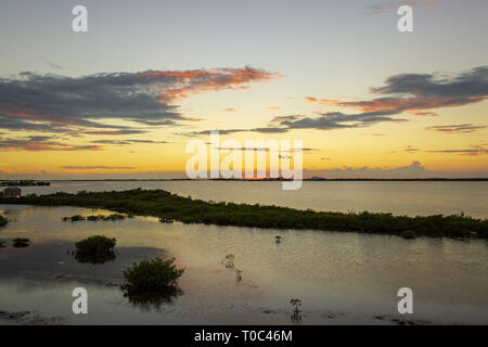 Le soleil se couche sur la baie de Chetumal sur Ambergris Caye, Belize casting teintes brillantes dans le ciel et se reflétant dans les eaux a ondulé par une brise chaude. Banque D'Images