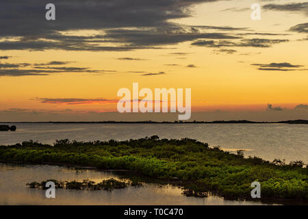 Le soleil se couche sur la baie de Chetumal sur Ambergris Caye, Belize casting teintes brillantes dans le ciel et se reflétant dans les eaux a ondulé par une brise chaude. Banque D'Images