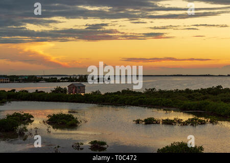 Le soleil se couche sur la baie de Chetumal sur Ambergris Caye, Belize casting teintes brillantes dans le ciel et se reflétant dans les eaux a ondulé par une brise chaude. Banque D'Images