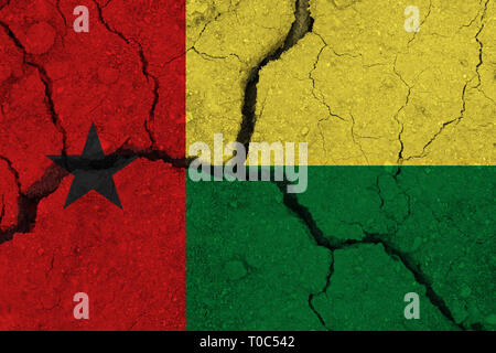 La Guinée-Bissau drapeau sur la terre craquelée. Drapeau national de la Guinée-Bissau. La sécheresse séisme ou concept Banque D'Images