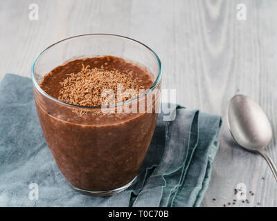 Chia chocolat au lait en verre sur table en bois gris. Avec petit-déjeuner végétalien sain de l'espace de copie. Banque D'Images