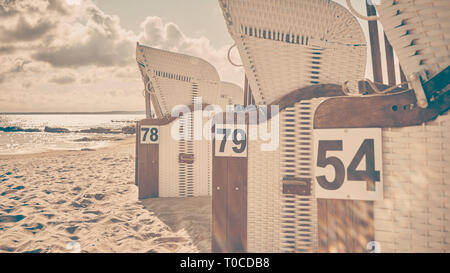 Retro photo stylisée de chaises de plage en osier sur une plage contre le soleil avec des reflets, selective focus. Banque D'Images