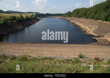 Les faibles niveaux d'eau au fond du réservoir d'Longdedale dans la vallée, Tintwistle, Derbyshire, Angleterre. Banque D'Images