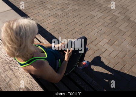 Active senior woman using mobile phone sur une promenade Banque D'Images