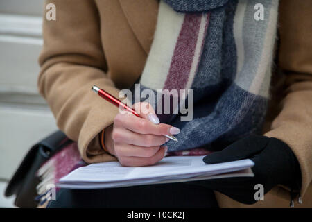 L'image d'une main et un stylo de remplir un formulaire. Femme avec les mains manucure pastel avec stylo. L'emploi. Document Signature Banque D'Images