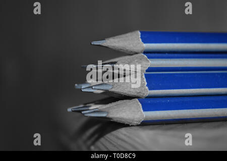 Crayons avec conseils aiguisés conservés sur une table. Photo en noir et blanc avec couleur bleu sélective Banque D'Images