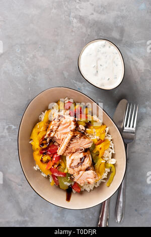 Saumon au four avec des légumes dans une assiette sur fond clair. Shot verticale Banque D'Images