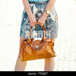 Street mode et beauté concept. Dame élégante de luxe portefeuille sac à main en cuir naturel dans les mains. Gros plan du sac à la mode moderne de femmes. Femme que je Banque D'Images