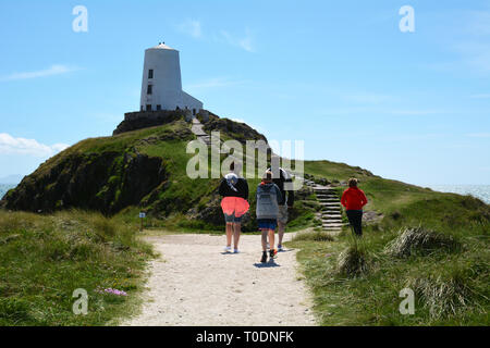 Les vacanciers visitent l'île Llanddwyn Lighthouse (Twr Mawr) de la côte d'Anglesey Banque D'Images