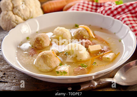 Soupe de printemps spécialiste allemand avec des boulettes de moelle dans un bouillon avec les carottes, chou-fleur et fromage aux herbes fraîches Banque D'Images